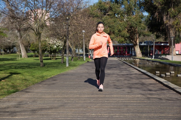 Young pretty woman jogging in city park