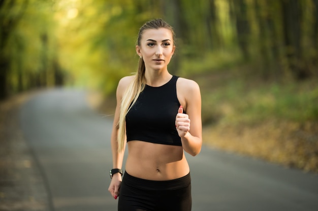 Young pretty woman jogging in the park in summer