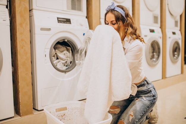 Foto gratuita giovane bella donna in una lavanderia a gettoni