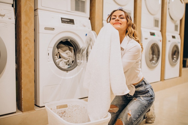 Foto gratuita giovane bella donna in una lavanderia a gettoni
