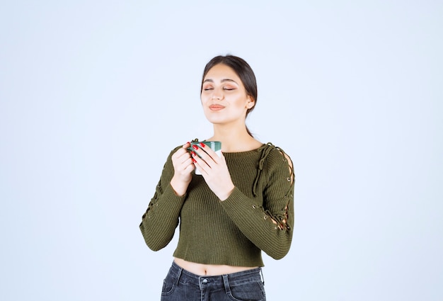 Free photo a young pretty woman model enjoying a cup of hot tea