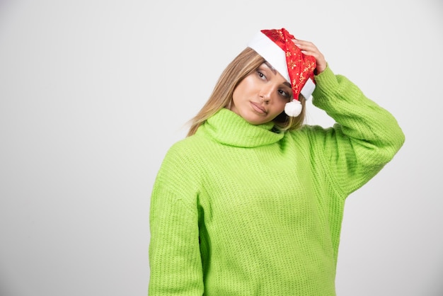 Young pretty woman posing in Santa Claus red hat .