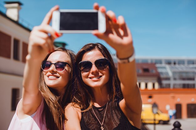 young pretty woman posing in the street with phone