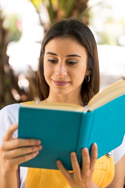 Young pretty woman reading book attentively