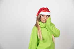 Foto gratuita giovane donna graziosa in cappello rosso di babbo natale