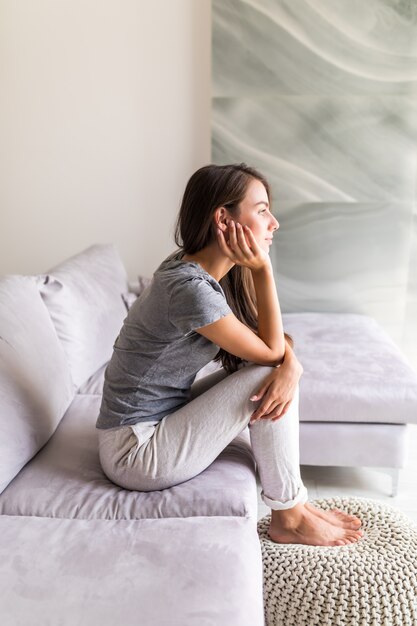 ソファに座って考えて若いきれいな女性