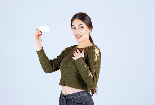 Young pretty woman standing with blank business card on white background.