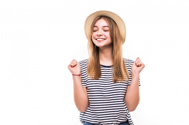 Young pretty woman in straw hat win gesture isolated on white wall