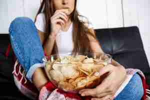 Free photo young pretty woman watching tv, sitting on sofa at home.