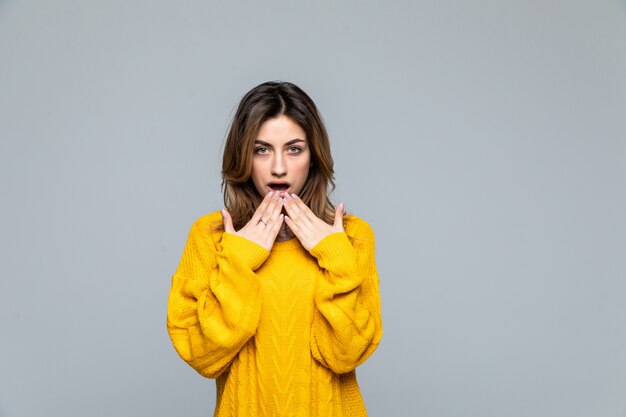 Young pretty woman wearing in yellow sweater isolated on gray wall