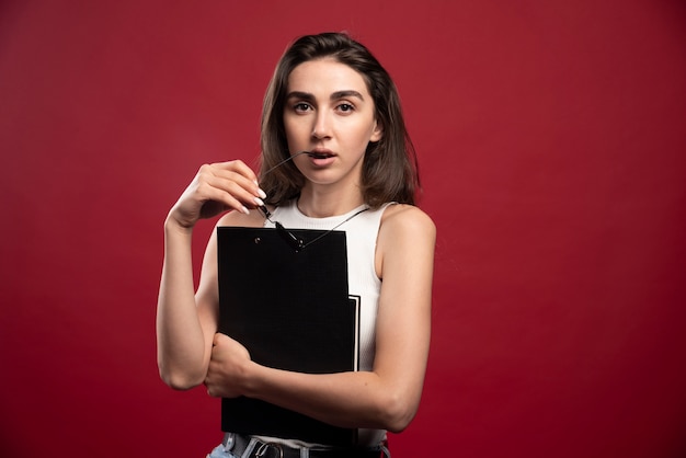 Young pretty woman with glasses holding notebooks 