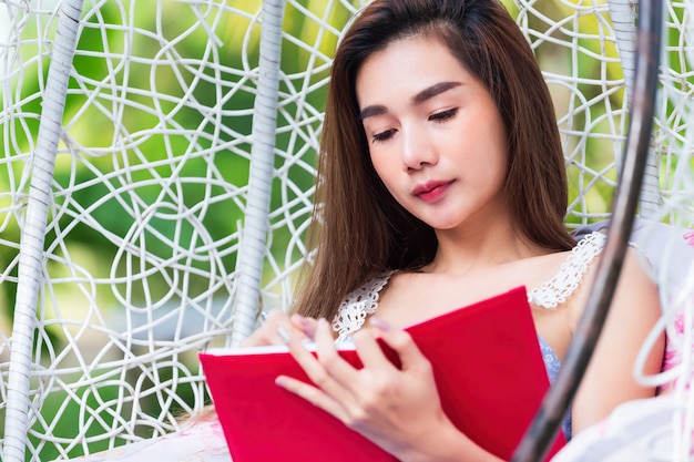 Young pretty woman with red diary in park