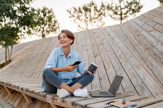 현대 공원 거리에서 노트북 작업을 하는 젊은 예쁜 여자