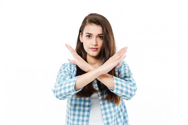 Young pretty young woman cross her arms to show gesture no