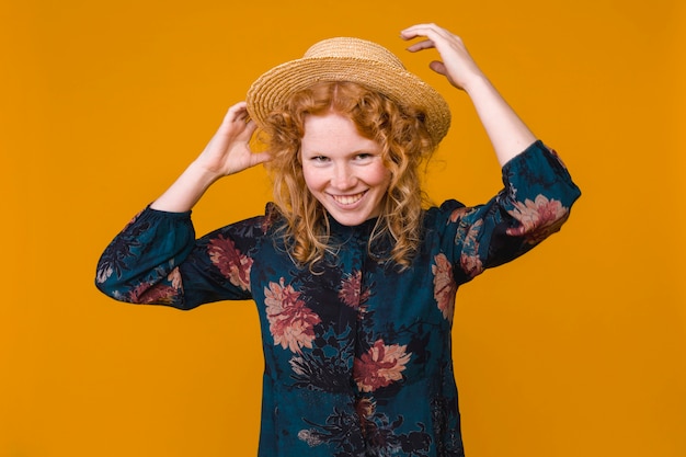 Young red haired woman in hat and dress