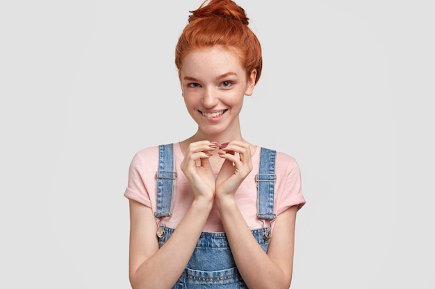 Young red-headed woman in denim overalls