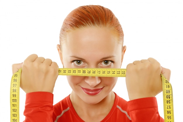 Free photo young red woman with measuring tape