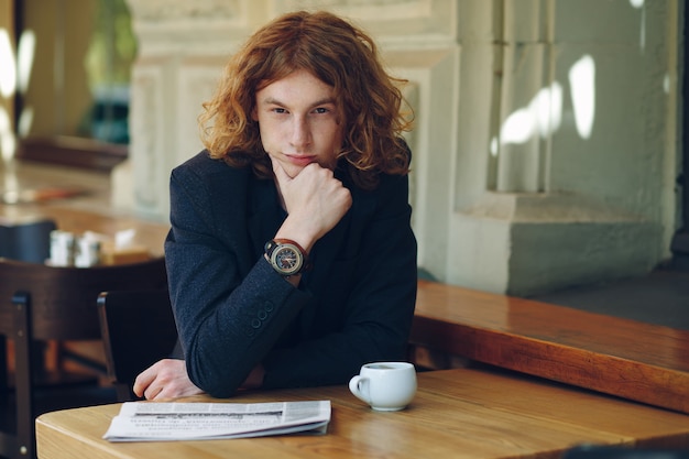 Young reddish man posing touching his chin