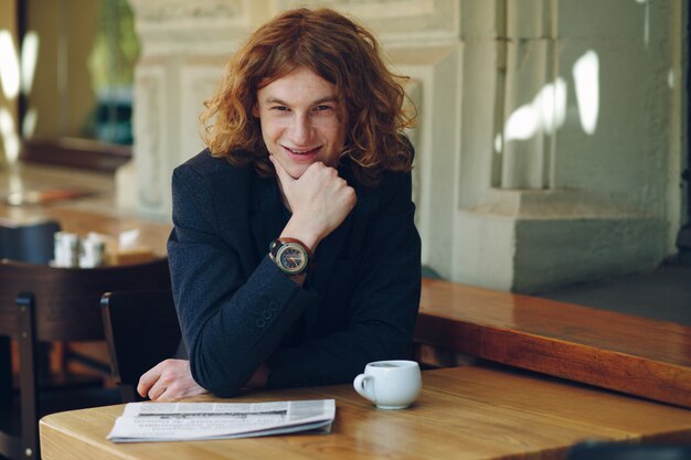 Young reddish man smiling touching his chin