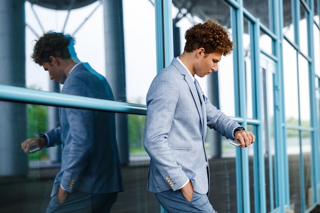 young redhaired businessman looking on watch