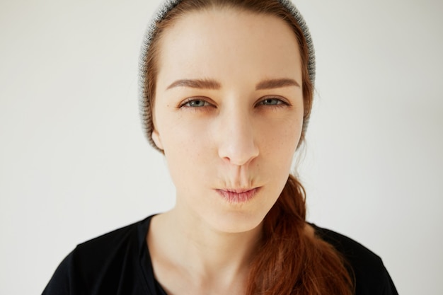 Free photo young redhead girl wearing hat and black t-shirt