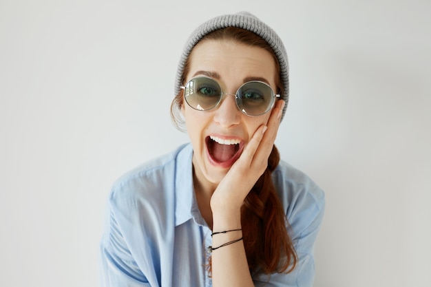 Young redhead girl wearing sunglasses and hat