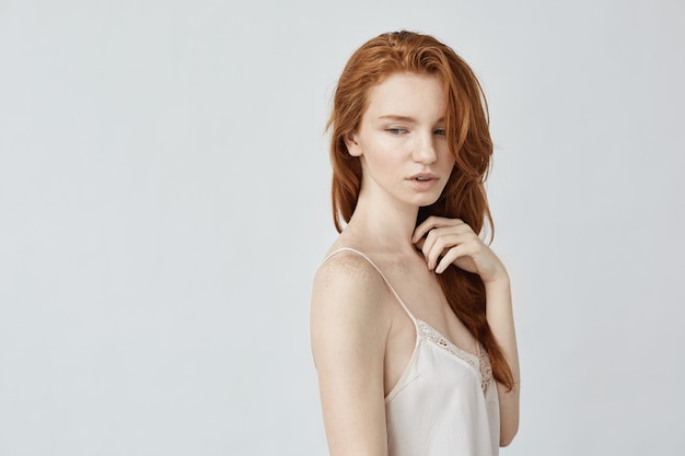 Young redhead woman posing in profile.