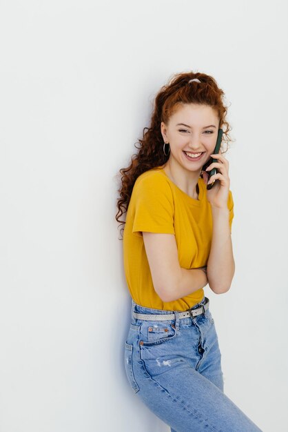 흰색 배경 위에 젊은 빨간 머리 여자 웃고 전화 통화 개념 의사 소통