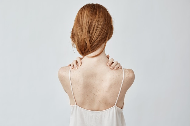 Young redhead woman with freckles posing back