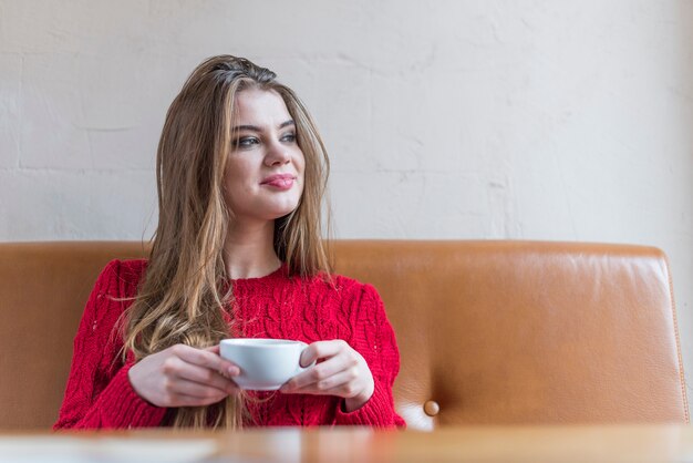 Молодая расслабленная женщина питьевой чашки чая