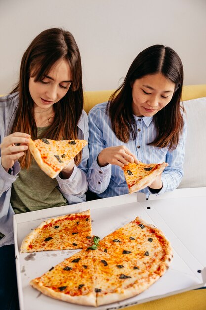 ピザを食べる若いリラックスした女性