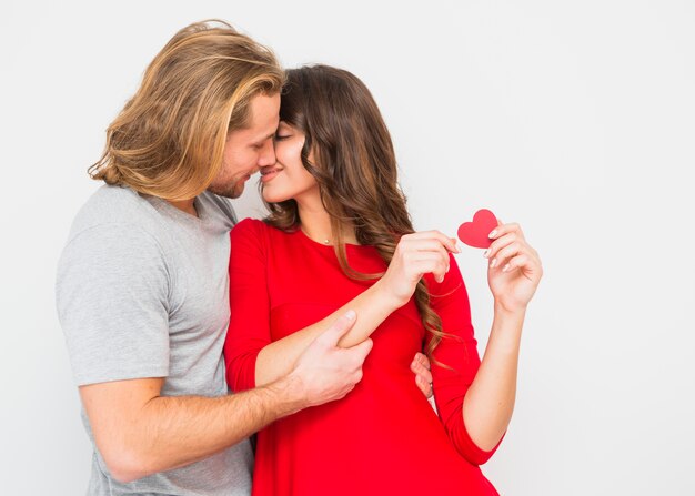 Young romantic couple kissing against white background