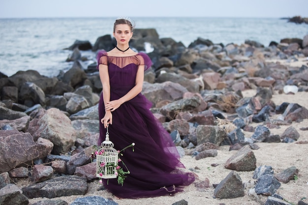 Young romantic woman posing on the beach watching the sunset