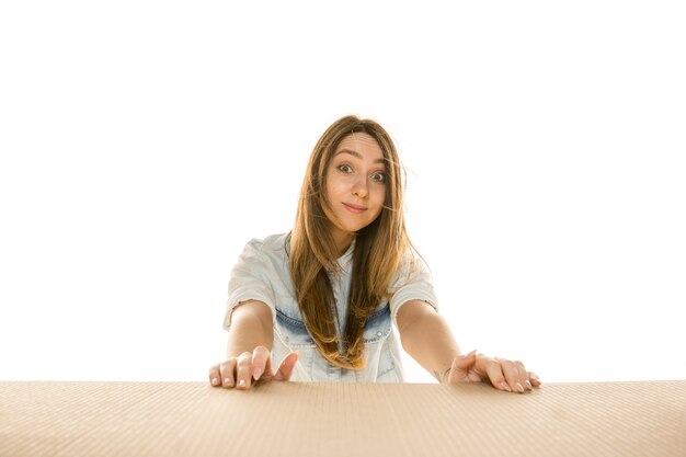 Young sad woman opening the biggest postal package isolated on white wall