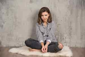 Free photo a young sad woman in plaid shirt blowing her cheeks.