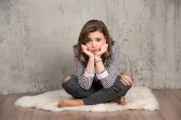 Free photo a young sad woman in plaid shirt blowing her cheeks.