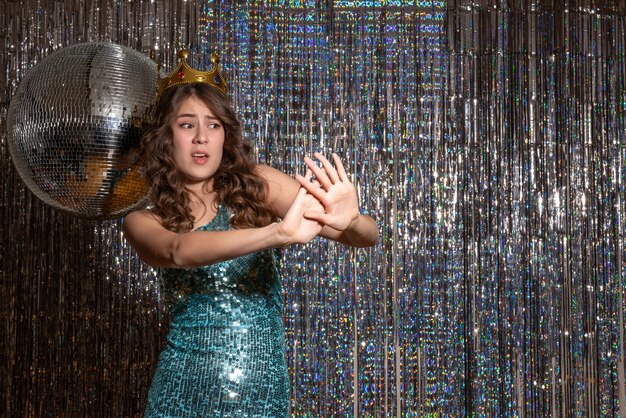 Young Scared Beautiful Lady Wearing Blue Green Shiny Dress With Sequins With Crown In The Party