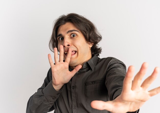 young scared handsome caucasian man pretends to defend with hands isolated on white background