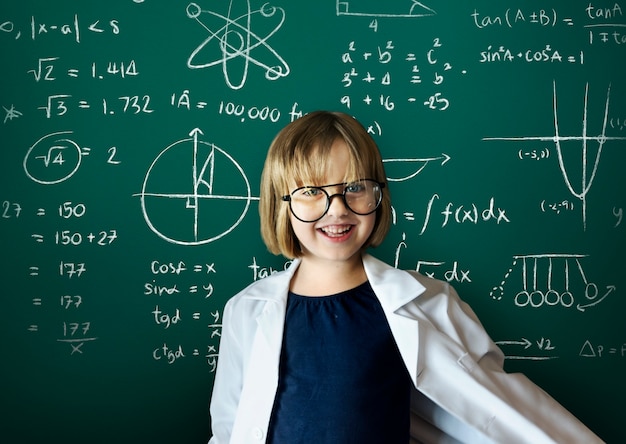 黒板の背景を持つ若い科学者の女の子