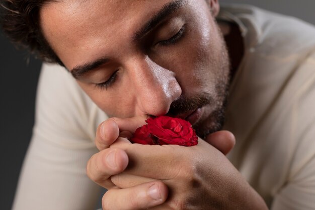 花を持つ若くて敏感な男