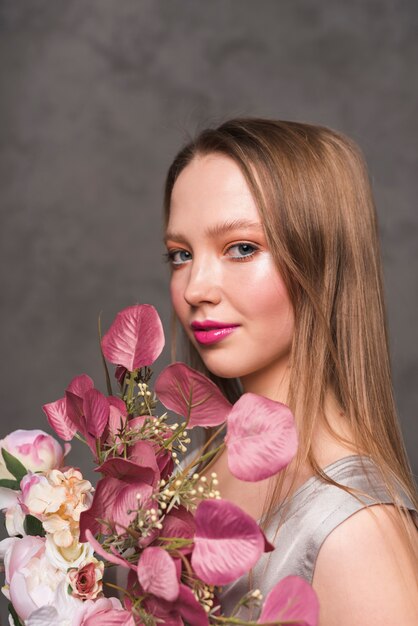 Giovane donna sensuale con bouquet di fiori belli