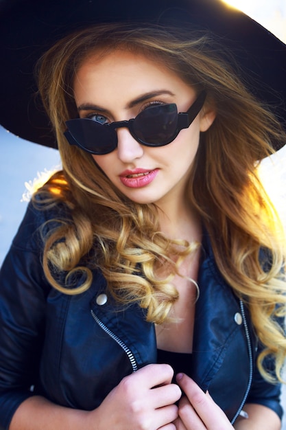 Young sensual pretty stylish blonde girl, with amazing long curled hairs