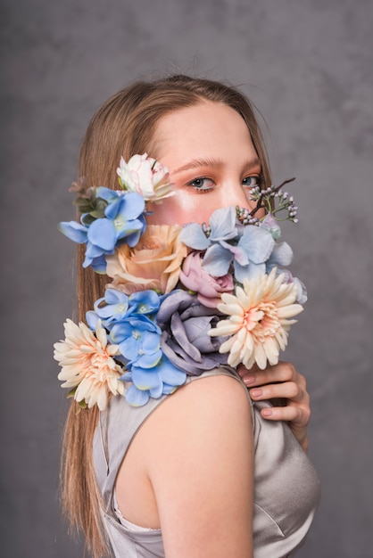 Foto gratuita giovane donna sensuale con bella composizione di fiori