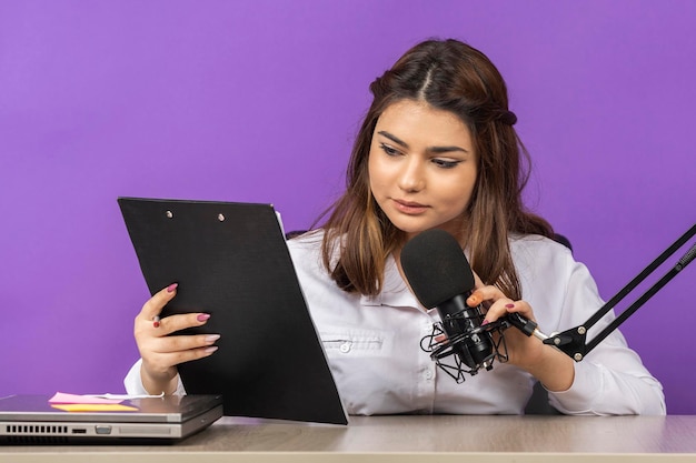 Free photo young serious girl reading her notes to the mic high quality photo