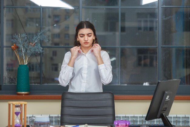 A young serious girl stands in the office