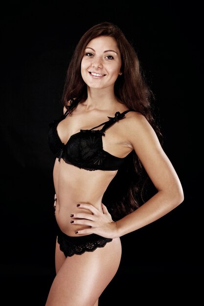 Young sexy brunette over black background