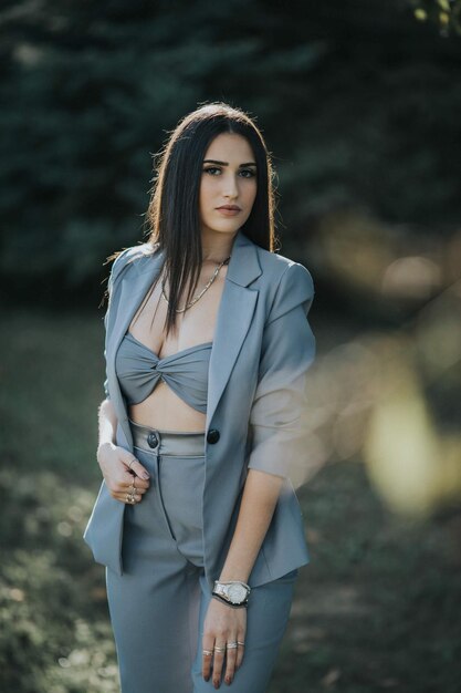 Young sexy Caucasian girl in a grey suit posing in the garden
