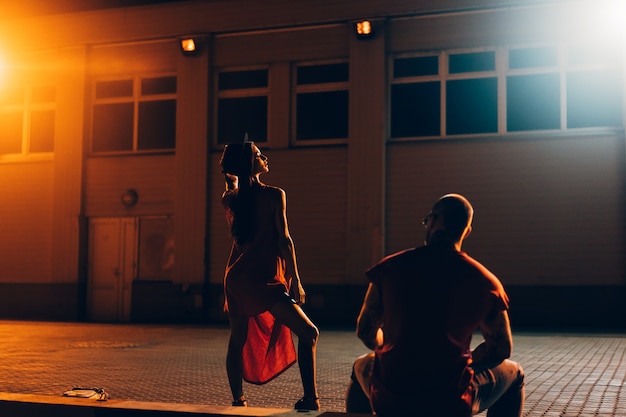 A young sexy couple lovers pose on the night street of the city.