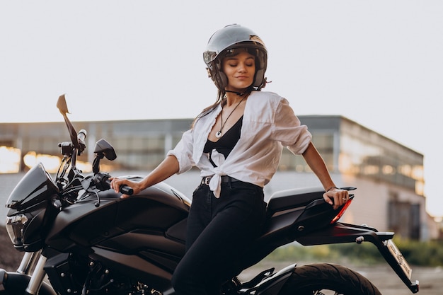 自転車で若いセクシーな女性モーターサイクリスト