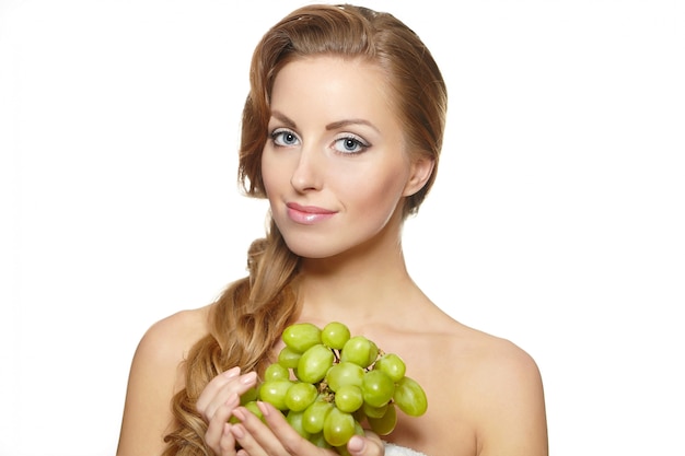 Young sexy smiling beautiful woman holding a bunch of grape in her hands with long hair isolated on white